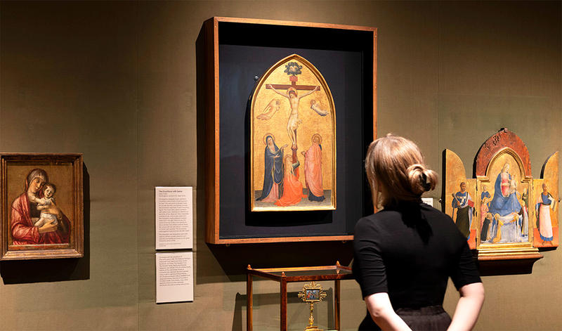 Fra Angelico's Crucifixion painting display with visitor